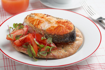 Roasted salmon with vegetables on a flat bread