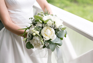bride with wedding bouquet. Morning at wedding day at summer. Beautiful mix white peonies and eucalyptus