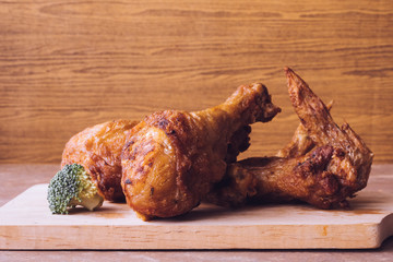 Fried chicken legs and wings on wooden tray.