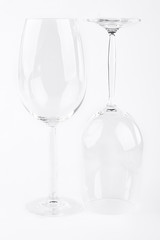 Two empty glasses for wine. Pair of clean empty wine glasses, one turned turtle. Crystal glassware for alcohol drink.