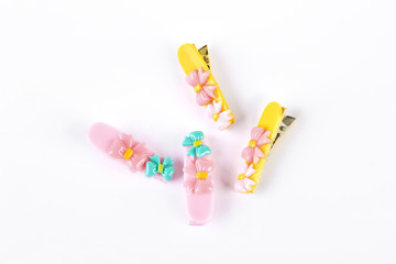 Two pairs of kid colorful hair clips. Pink and yellow hairpins for girls on white background. Childrens hair accessories.