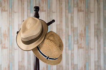 Straw hat hanging on wooden hanger.clothing accessories and travel concept