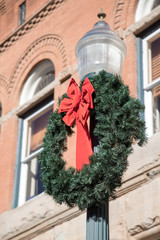 Christmas wreath on a lamp post in front of a building