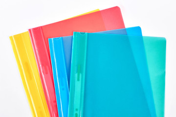File folders on white background. Composition of four plastic envelopes of different colors on a...