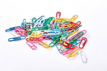 Heap of colorful plastic paper clips. Many multicolored paper clips isolated on white background.