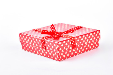 Red gift box with bow. Red present box with a pattern of white stars isolated on white background. Birthday gift concept.