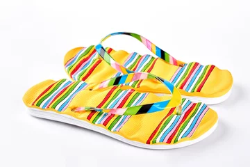 Fotobehang Summer fashion flip flops on sale. Female yellow striped flip flops on white background. Summer fashion concept. © DenisProduction.com