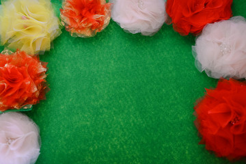 Closeup top view of beautiful flowers handmade fabric on green flat lay textured bright background