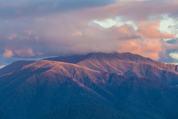 Australian Alps in orange sunset light and low clouds