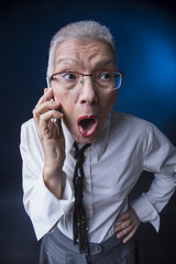 Senior old business woman shocked and worried with the news she receives over her cell phone