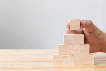 Hand arranging wood block stacking as step stair. Business concept for growth success process