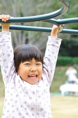 Obraz premium 公園の遊具で遊ぶ女の子