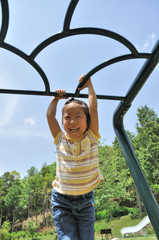 Fototapeta premium 公園の遊具で遊ぶ女の子