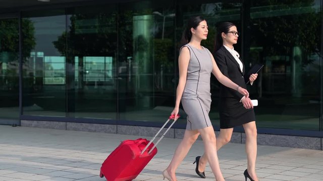 two asian business manager carrying suitcase