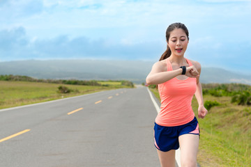 happy attractive girl runner using smartwatch