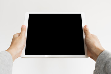 Hands holding modern digital tablet, blank black screen, on white background