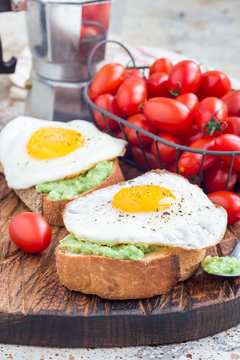 Open sandwiches with mashed avocado and fried egg on bread, vertical