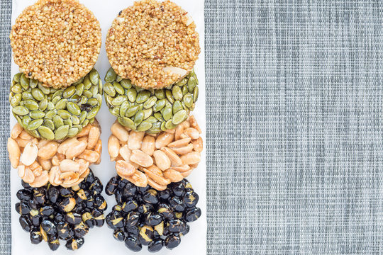 Korean traditional sweet snacks with peanuts, pumpkin seeds, black soybeans and chinese buckwheat. Top view, horizontal, copy space