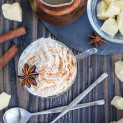 Hot white chocolate, decorated with whipped cream and cinnamon, top view, square