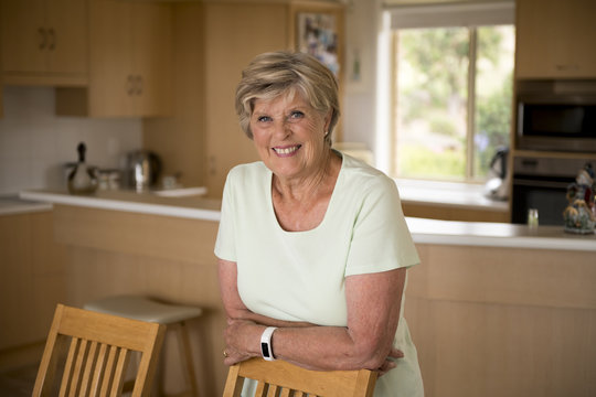 Beautiful Portrait Of Pretty And Sweet Senior Mature Woman In Middle Age Around 70 Years Old Smiling Happy And Friendly At Home Kitchen