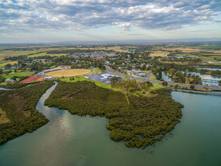 Fototapeta na wymiar Aerial view of mangroves and small coastal town in Australia at sunset