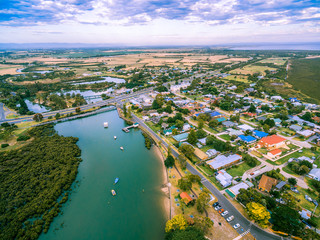 Aerial view of rural homes and river near ocean in Australia