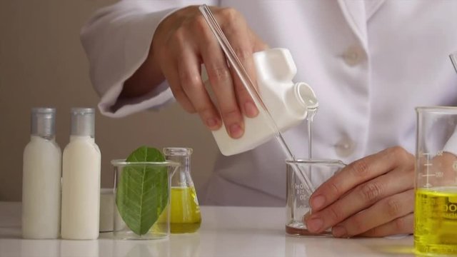 the scientist,dermatologist testing the organic natural cosmetic product in the laboratory.research and development beauty skincare concept.blank package,bottle,container .cream,serum.