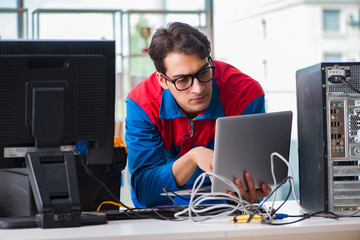 Computer repairman working on repairing computer in IT workshop