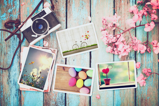 Retro camera and paper photo album on wood table with flowers border design - concept of remembrance and nostalgia holiday in spring. vintage style