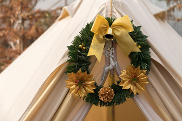 Christmas garland with leaf and ribbon on wood stick with tent camping