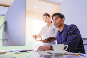 group of designer working graphic on computer with color chart and write short note for choose a color