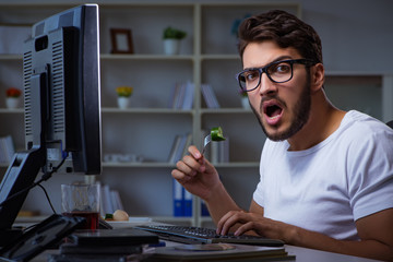 Young man staying late in office to do overtime work