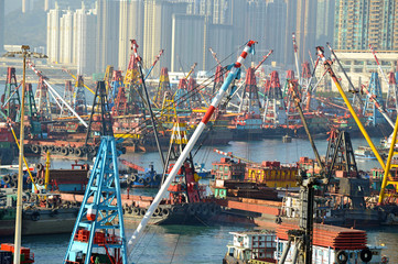 Commercial Barges with industrial freight cranes and marine shipping containers with city skyline,...