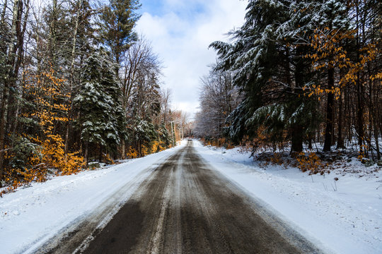 View of empty road passing through forest in winter