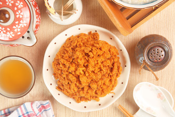 Dried shredded pork (or pork floss) with tea and gruel  on wooden table     