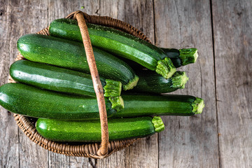 Fresh zucchini, green vegetables, farm fresh organic produce from farmer market, overhead in the basket