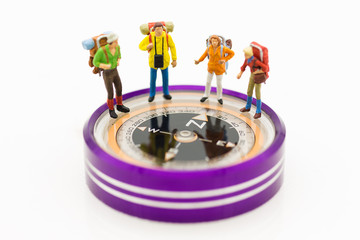 Miniature people: Group of backpacker standing on compass ,using as background travel, business concept.