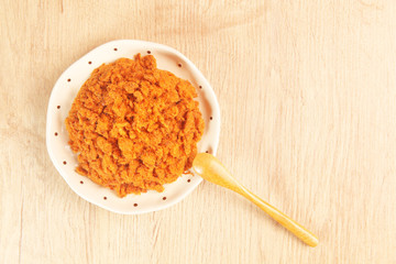 Dried shredded pork in a plate on wooden table.