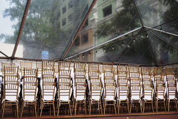 Event Setup Chairs Stacked in Clear Tent in Urban Setting