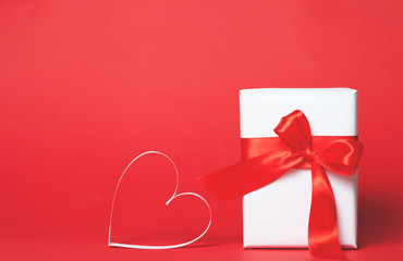 Gift box with hearts on red background. Top view, flat lay. St. Valentine's day greetind concept