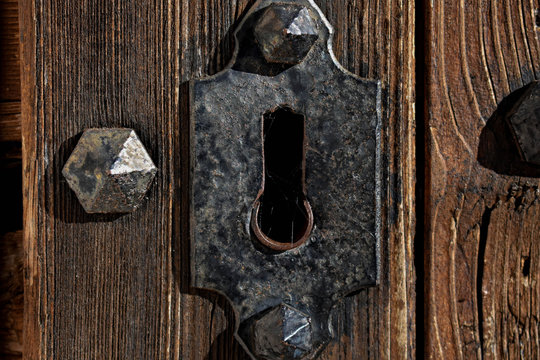 Closeup Of An Isolated Rusty Floral Shaped Keyhole On Splintered Grey Wooden Door