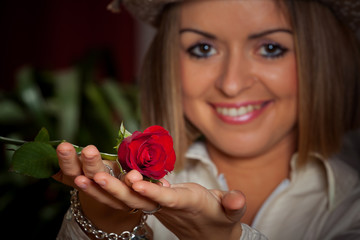 Close-up portrait of young beautiful woman with red rose