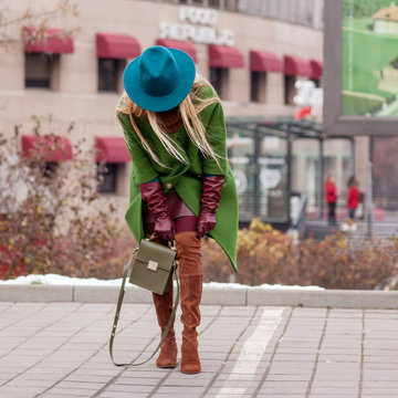 Street, bright style A young woman in a green coat, a hat and a khaki bag. Details. Sguare image photo