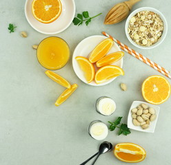 healthy breakfast of freshly squeezed orange juice, oatmeals and pistachio nuts on a light gray table. top view