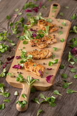 Fresh freshly fried delicious slices of meat on a wooden board with fresh herbs. Appetizing steaks on a wooden board. Still life.