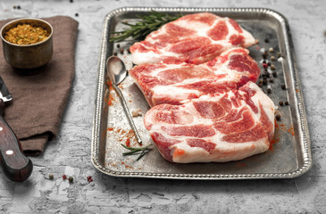 Raw steaks for cooking on grill on tray