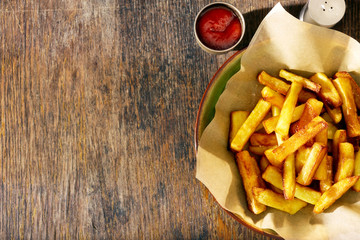 Fried potatoes plate pan ketchup wooden background border, top view