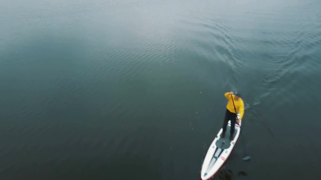 Sup board aerial drone footage. Closeup of a professional rower demonstrating stand up paddling techniques.