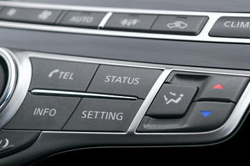 Luxury car inside. Interior of prestige modern car.  Black perforated leather cockpit. Media control buttons in black leather with navigation computer monitor screen