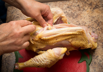 The cook cuts the chicken with a knife